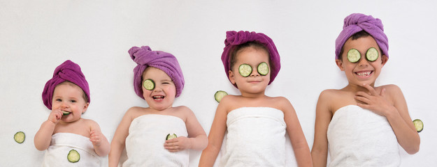 Funny kids and baby in bath turbans and towels getting beauty treatments
