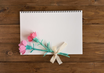 A sketchbook with flowers,carnations made of handmade used felt, on wooden background.(34-2）