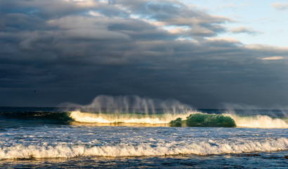 Powerful ocean wave breaks on a shallow bank. Stormy weather. Seascape.