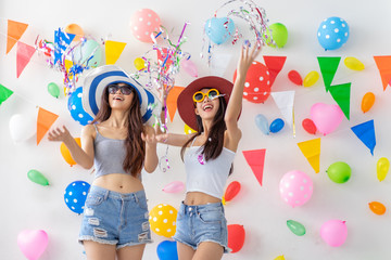 celebration new year or birthday party group of asian young woman and confetti happy,funny concept.drinking wine happy and fun in new year celebrate, color balloon  background.