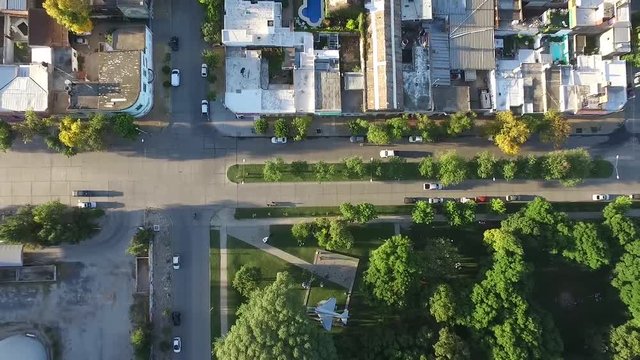 Drone Aerial top view of a city corner near a silo agriculture facility and a square with a war plane in it