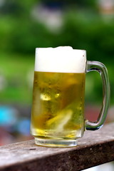 Cold beer with blur background , on the wooden handrail at Boklua view resort, Nan Thailand.