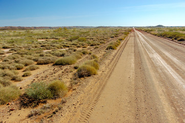 Long red dirt road in Pilbra region in Western Australia disappears in haze