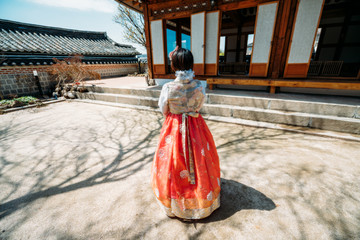 Young woman traveler in traditional korean dress or call hanbok traveling into Bukchon Hanok Village at Seoul city in South Korea