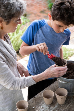 Boy and his grandmother planting seeds for the garden