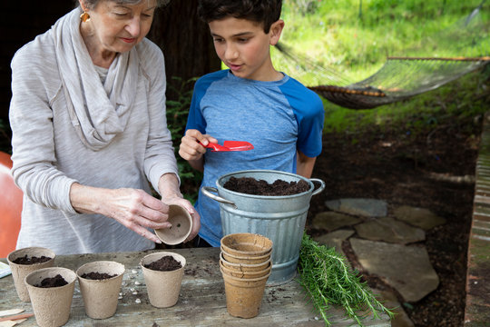 Boy and his grandmother planting seeds for the garden