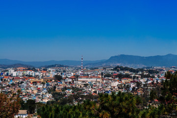 Buildings in Dalat city center and mountain with blue sky
