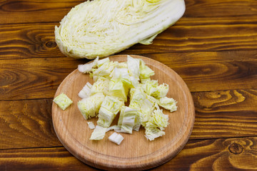 Chopped chinese cabbage on cutting board on wooden table