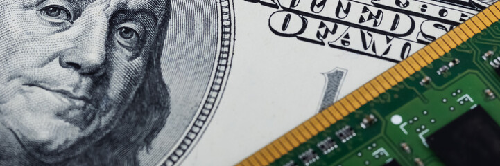 Computer board and one hundred dollars bill closeup.
