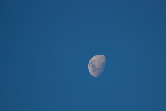 lua crescente no c&eacute;u azul do dia