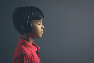 Indian young boy listen music with headphone