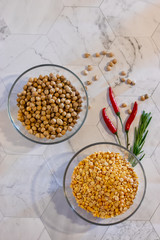 chickpeas and peas in transparent plates with hot peppers on a light background of vertical orientation