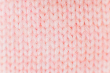 closeup of pink knitted fabric texture. facial loops. stockings with knitting needles and pink woolen thread