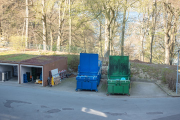 two garbage compactors are standing in the courtyard of a hospital
