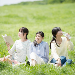 草原でピクニックをする3人の女性