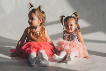 two little girls playing on the floor on a white background