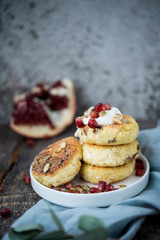Cheesecakes for Breakfast decorated with pumpkin seeds and pomegranate seeds. Selective focus.