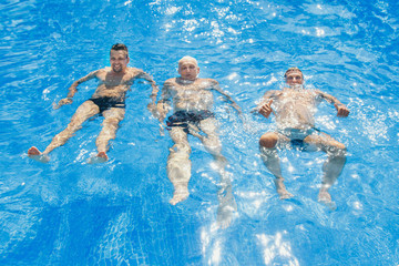 a group of men swimming in the pool