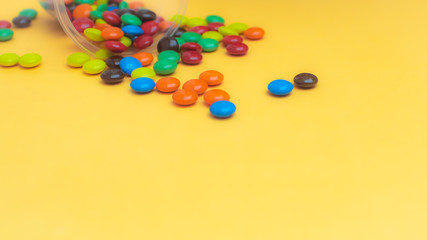 Obraz premium Colorful Delights: Close-Up of Chocolate Coated Candy Pile with Joyful Background