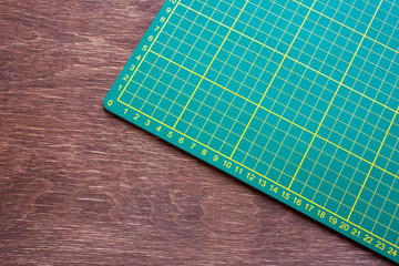 green cutting mat on a wooden table