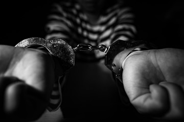 Businessman being handcuffed to a prisoner
