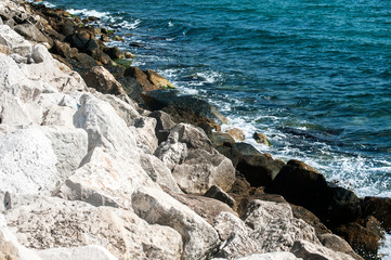 Fototapeta na wymiar White rocks of seaside coastline closeup in sunny summer day