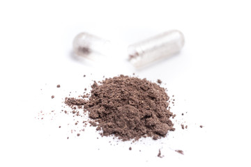 Herbal medicine in capsule isolate on white background. Herb black Galingale powder extract. Herbal medicine with open clear capsules. Alternative supplement for good healthy.