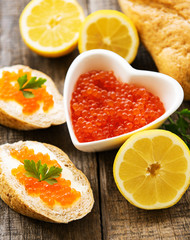 Obraz na płótnie Canvas Red caviar in bowl and sandwiches