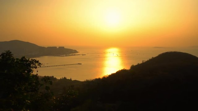 Gorgeous sunset sky over Sanya resort in China. Panoramic view of calm sea waves.