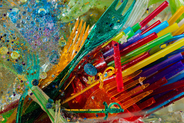 Fototapeta premium Transparent plastic forks being mixed with straws and glitter