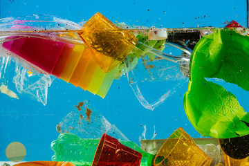 Broken colorful plastic mess floating in dirty water
