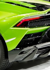 Green shiny modern sports car body tail light and carbon fiber components - obrazy, fototapety, plakaty