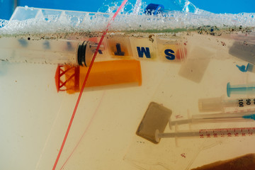 Heap of plastic syringes placed in transparent bag