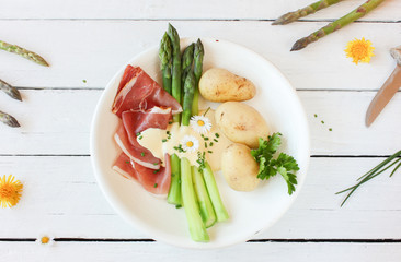 frischer grüner Spargel gekocht mit Kartoffeln und Schinken von oben Teller 