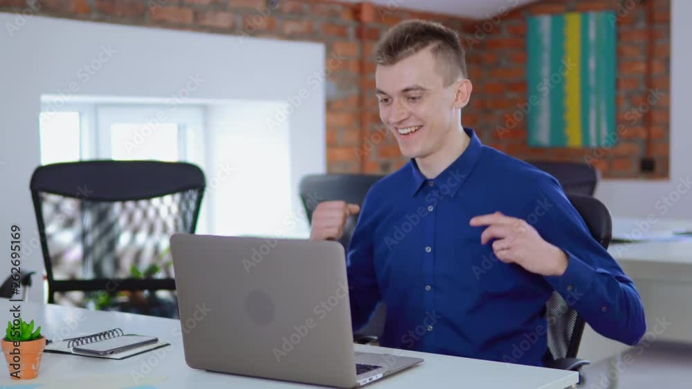Poster Man browses through internet, writes a report at workplace. Male worker with computer and paper working in office.