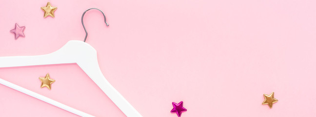 White hangers on pastel pink background