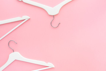 White hangers on pastel pink background