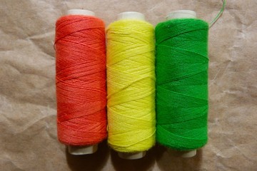 bright fablue silk foldclose-up bobbins with threads stripes abstraction natural fabric ice color texture backgroundbric tropical pattern abstraction blue red yellow green decor background