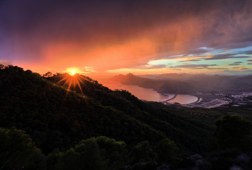 Dramatic evening sky at sunset high above the lighthouse of Portman and a bay at Cartegena in Spain.