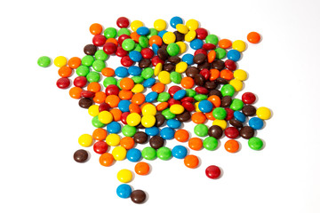 Colorful chocolate M&Ms in and out of focus on white background