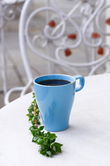 Fragrant coffee in a beautiful cup. Cup outdoors on a wooden table.