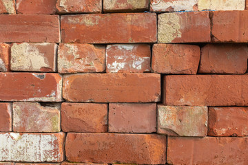 A pile pf red coloured bricks used in construction ready to use