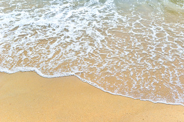 Fototapeta na wymiar Soft waves of blue ocean on sandy beach