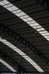 Interior of sport hall, seeing inside steel arch roof with sun glass, truss and sport lighting pendents.