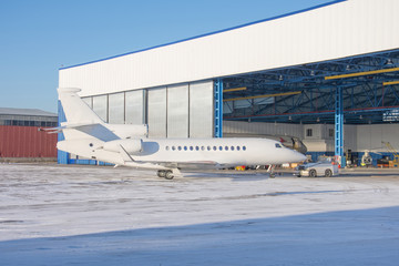 Aircraft is delivered inside via tow-tractor the aviation hangar for maintenance.