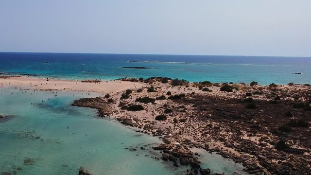 Elafonissi beach aerial shot with a surfer paragliding on this scenic wite sand beach located on the island of Crete, Greece