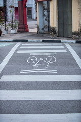White bicycle sign painted on the street indicating bicycle lane.
