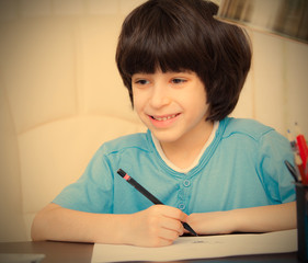 smiling child doing homework with computer