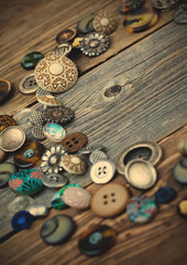 Obraz na płótnie Canvas placer of vintage buttons on aged boards