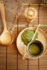 Top view of green tea matcha in a bowl on wooden surface